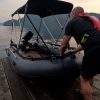 man pulling an inflatable dinghy to shore after a lovely day on the water