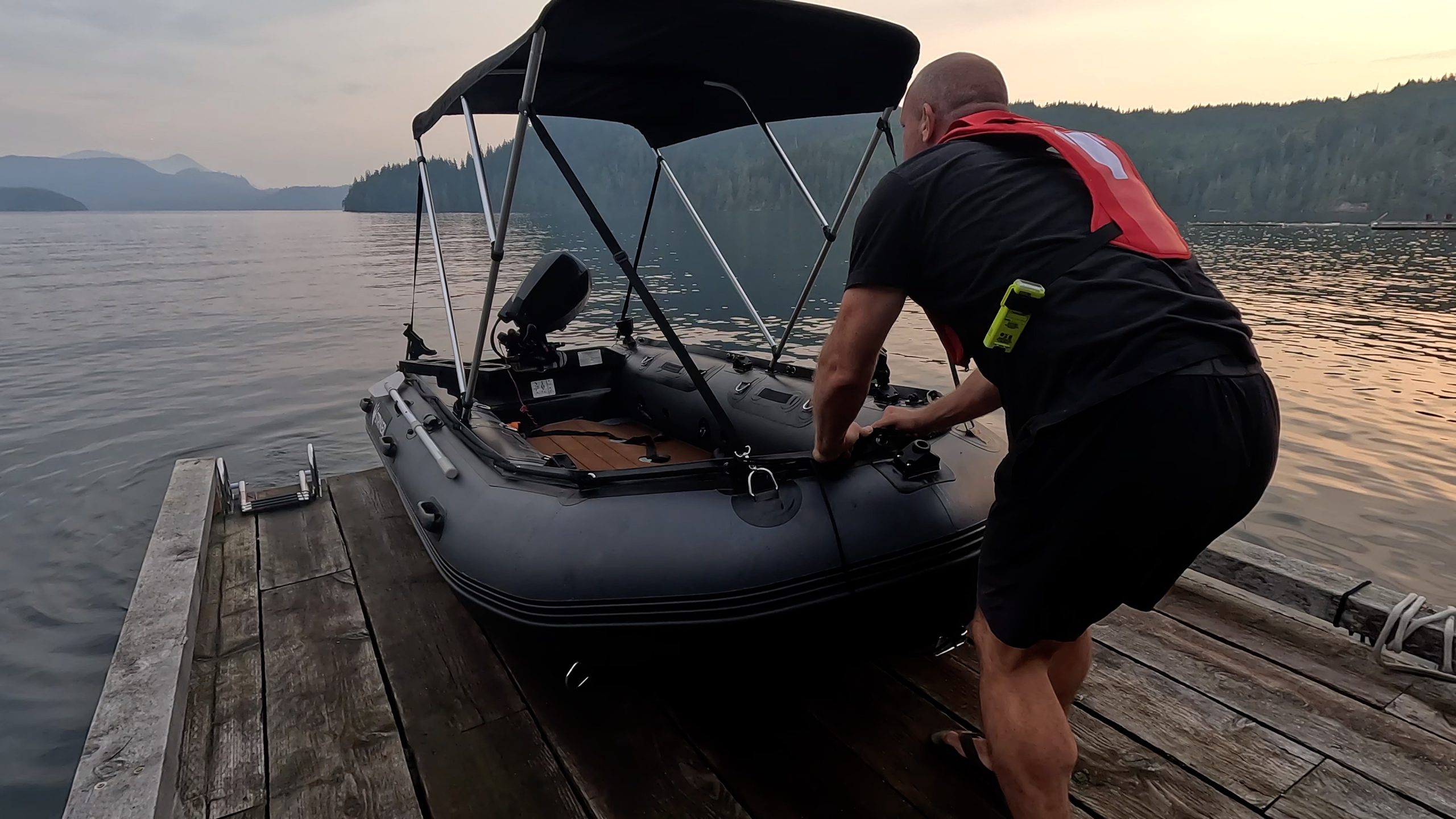 man pulling an inflatable dinghy to shore after a lovely day on the water