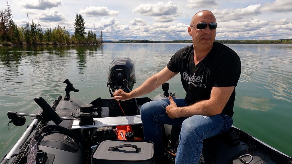 man getting ready for a trip in his inflatable boat on shore