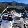 woman driving white tender yacht dinghy cruising on the water