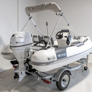 white rigid hull inflatable boat with bimini, integrated console and tohatsu outboard on road runner trailer