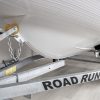 white rigid hull inflatable boat on road runner trailer