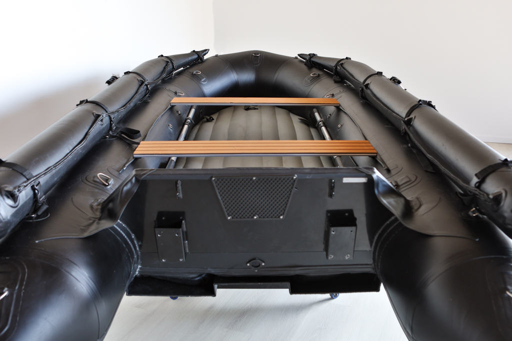 rear view from stern stealth black inflatable jet boat in showroom with a close up of top tubes